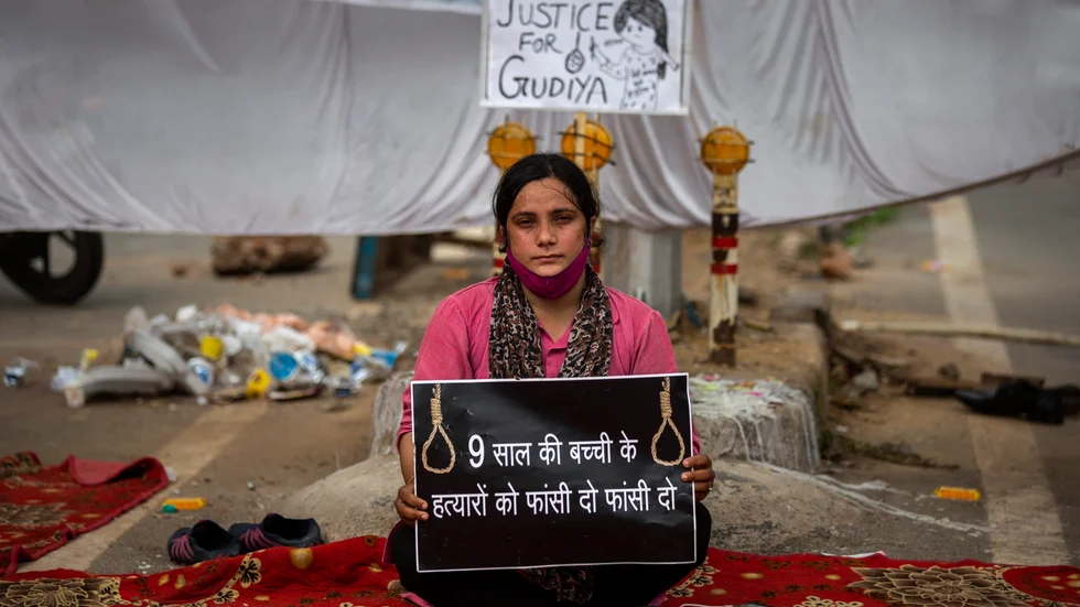 Aktivisten Tina Verma håller en skylt med texten "häng nioåringens mördare" i indiska Delhi.