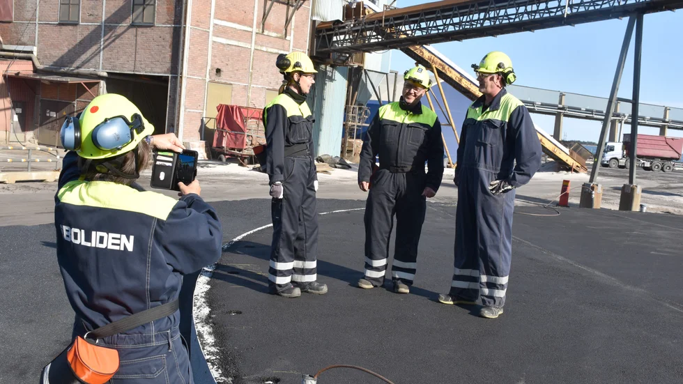 Kommunikationschefen Ann Lundholm fotograferar Leena Harjumaa, Tommy Berglund och Stefan Wikdahl, alla i Ecolink-projektet, på platsen där bottenplattan för nya stora ackumulatortanken finns på Boliden Rönnskär.
