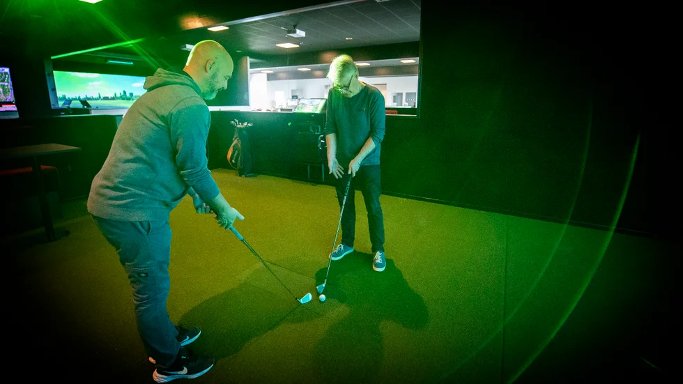 Johan Ekström (till höger) går igenom hur man bäst håller i en golfklubba. Sedan gällde det att träffa bollen också. 