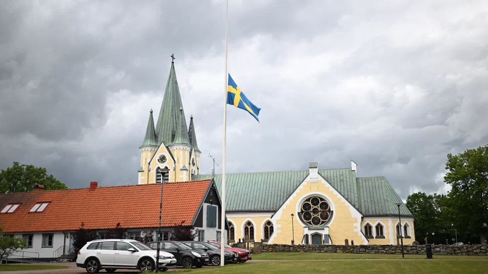 Flaggan vajar på halv stång i samhället där en vuxen person och ett barn hittats döda i en bostad.