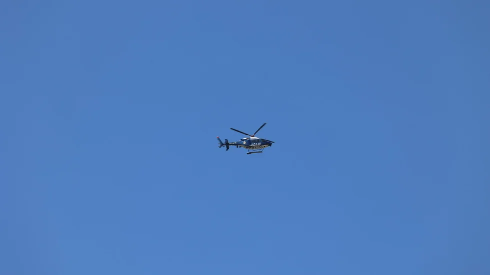 Polisen använder helikopter under sökandet av den försvunna kvinnan.