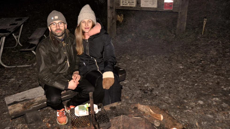 Alexander och Emma värmer sig vid brasan efter en vandring runt leden i Fjällnora.