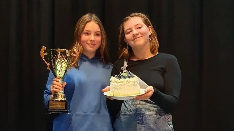 Alva Sjöström med pokalen och Märta Wrede med den vinnande tårtan.