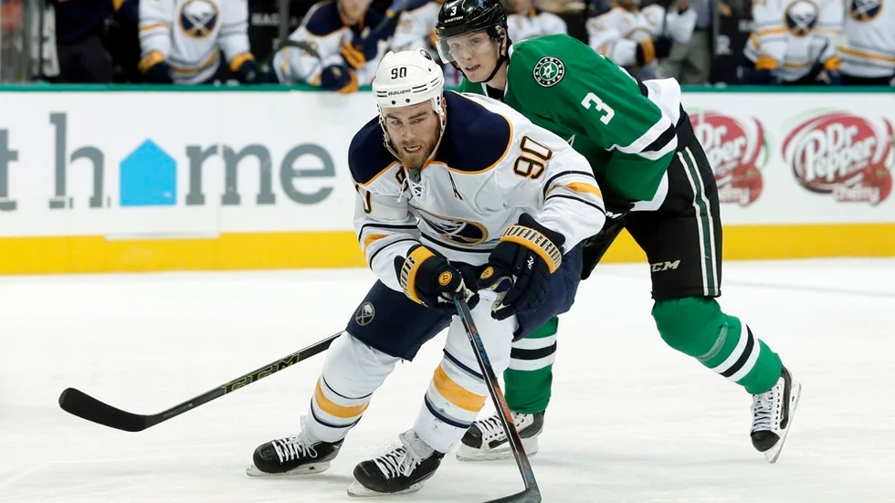 John Klingberg gör succé i NHL. Här i nattens match mot Buffalo i kamp med Ryan O'Reilly. Foto: Tony Gutierrez.
