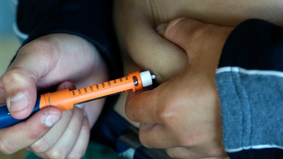 Pojke med diabetes tar insulinspruta.
