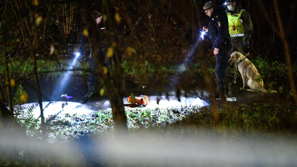 Kriminaltekniker och hundpatrull arbetar innanför avspärrningarna runt en gångbana vid Leksaksgatan i Osby efter att en man hittats skottskadad.