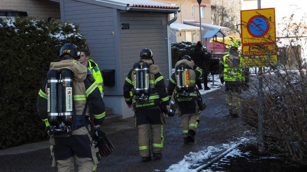 Brandmän på väg genom bostadsområdet för att kontrollera branden.
