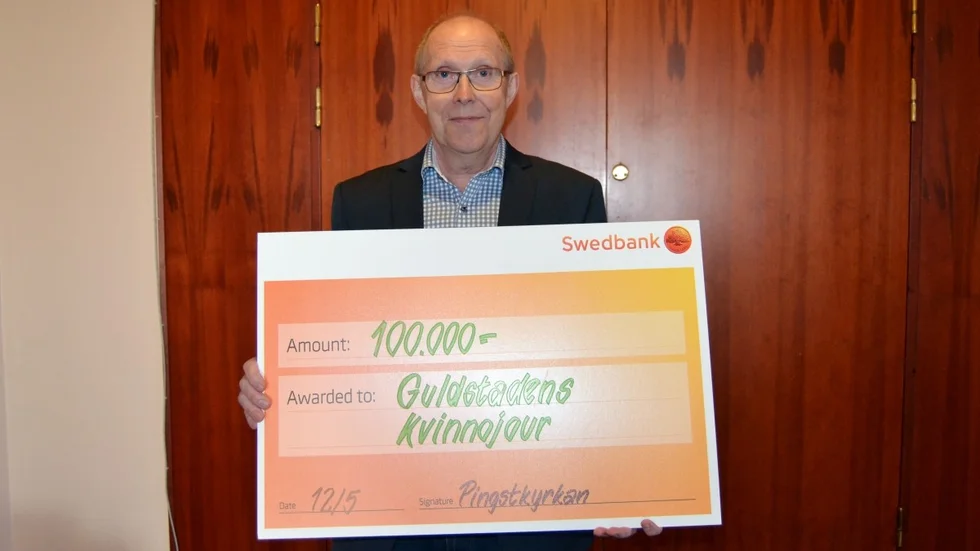 Lars-Erik Lönnebo, social pastor i Pingstkyrkan i Skellefteå, med checken till kvinnojouren. Foto: Emma Kärnebro