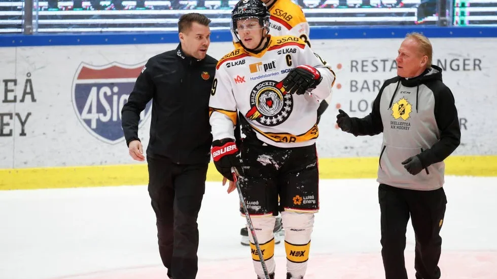 Här får Luleå Hockeys lagkapten Erik Gustafsson hjälp att ta sig av isen efter att ha åkt på en tackling bakifrån från Skellefteås Emil Djuse.