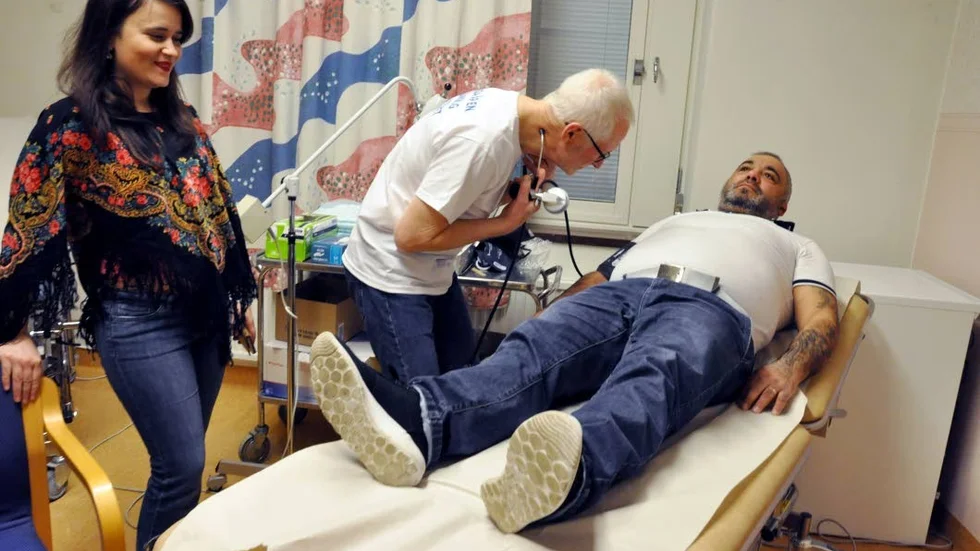 Volontärläkaren Ingemar Persson kollar Ioan Munthes blodtryck och hjärta medan tolken Ana-Maria Ristic översätter. All utrustning i mottagningens två rum i Ulleråker är skänkta av företag och organisationer.