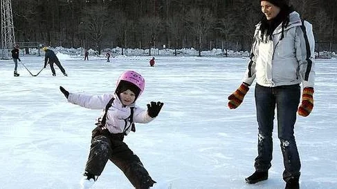 Ellinor Bengtsson prövar sina julklappsskridskor. Mamma Louise Bengtsson tittar på.