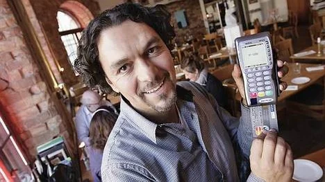 Joseph Lahyani, delägare i restaurangen Biztron, visar upp den bärbara kortterminalen.