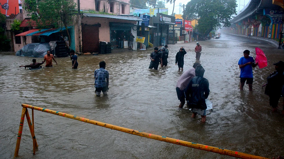 Människor vadar i högt vatten i Tamil Nadus delstatshuvudstad Chennai.