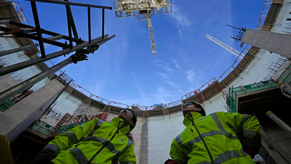 Anställda tittar upp vid det pågående bygget av Hinkley Point C i engelska Somerset. Bild från 2022.