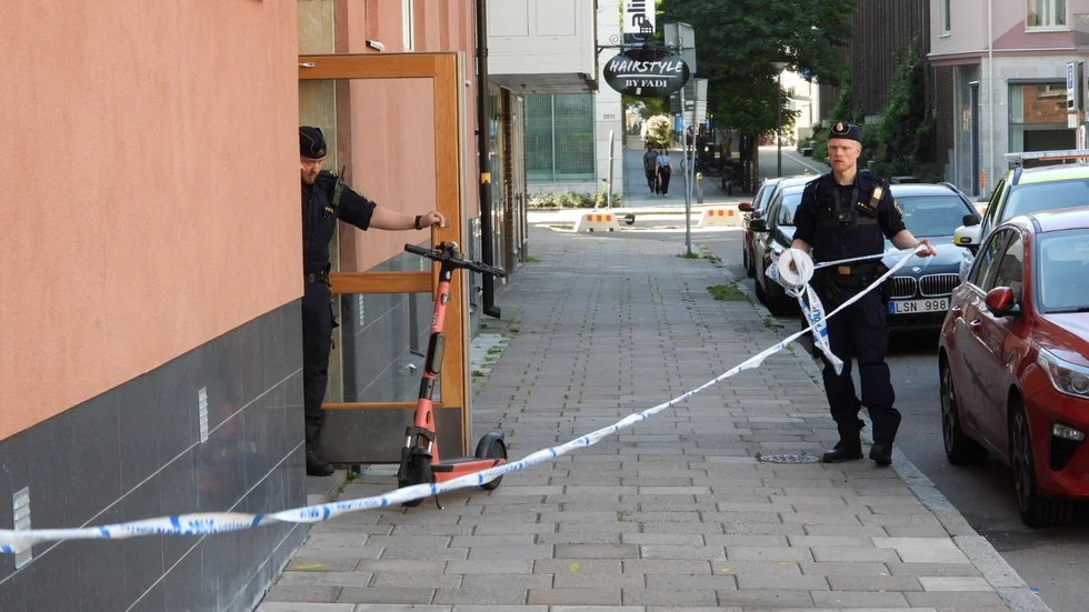 Här  spärrar polis av platsen runt husets entré.