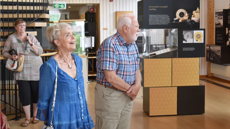 Ingegerd Johansson och Hasse Fredriksson lyssnar med intresse när de guidas i utställningen.  