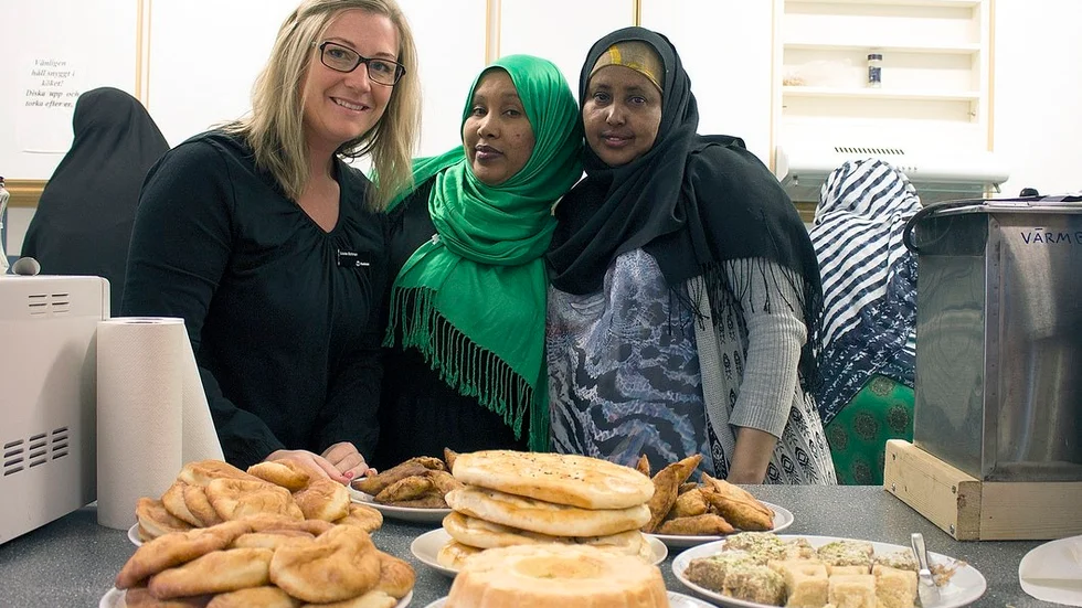 Louise Bohman, Kadija Abdulahi och Salado Ali visar upp den mat som gruppen lagat den här dagen. "Vi har blivit som en stor familj", säger Louise.