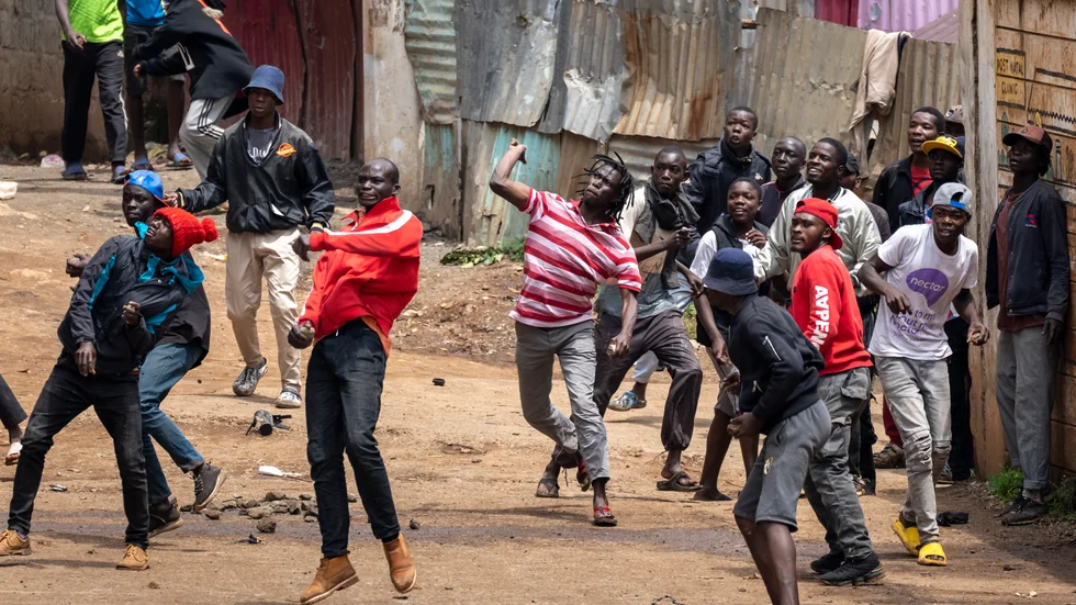 Människor kastar sten mot kravallpolis i slumområdet Kibera i Kenyas huvudstad Nairobi på tisdagen.