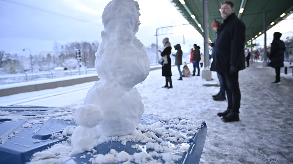 Snögubbar och resenärer på Kallhälls pendeltågsstation i Stockholm.