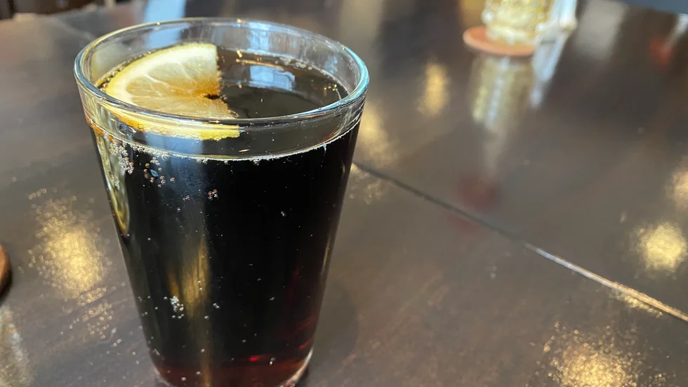 En kvinna har åtalats misstänkt för ofredande efter att hon hällt läsk över en annan kvinna på en hamburgerrestaurang i Visby.