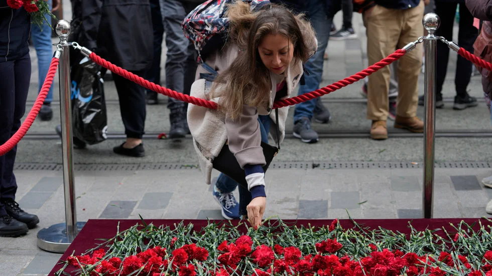 En kvinna lämnar en blomma vid minnesplatsen som upprättats på gågatan Istiklal i centrala Istanbul dagen efter dådet.