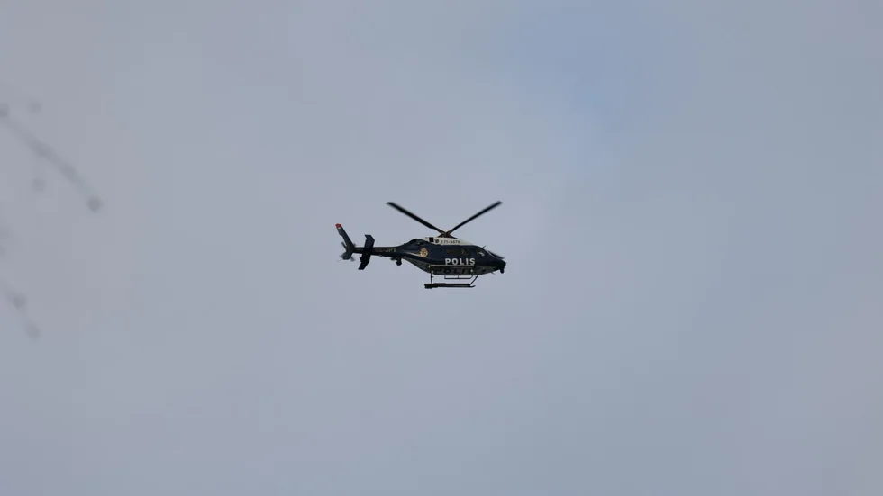 En polishelikopter deltar i polisinsatsen.