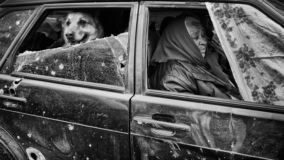 Fotografen Eddy van Wessel är nominerad i kategorierna årets fotograf och årets bild. Här en bild av en kvinna och hennes man och hund som har lyckats ta sig ut från en ukrainsk by som varit belägrad av den ryska armén.