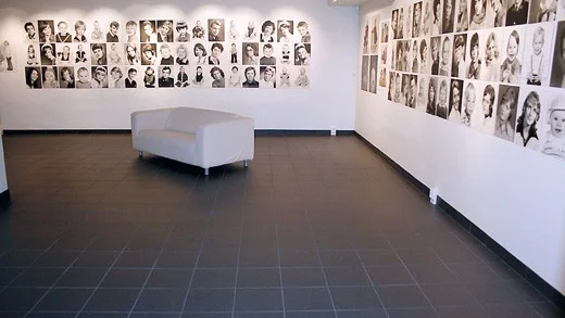 Väggarna i Eksjö museums stora utställningshall har tapetserats med porträtt av folk från Eksjö med omnejd. Foto: Lisa Ugarph, Eksjö museum