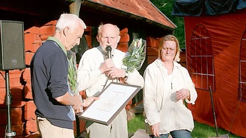 Ulf Brushane tar emot diplom, blommor och guldnål.