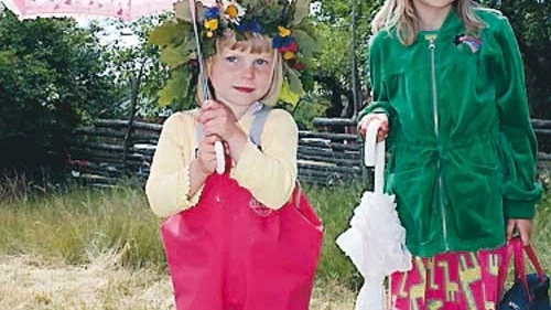 Syskonen Lovisa, 4, och Ottilia Klint Johansson, 7, var beredd på regn när de firade midsommar i Ingatorp.
