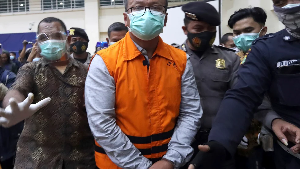 Två ministrar har på kort tid pekats ut som misstänkta för mutbrott i Indonesien. Bilden visar när fiskeriminister Edhy Prabowo förs bort efter att anklagelserna mot honom presenterats. Arkivbild.