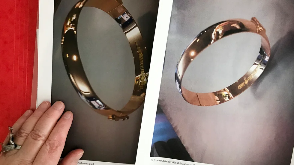 Karin Nygren visar bilder på det stulna armbandet. Bilderna finns i polisens förundersökningsprotokoll. 
