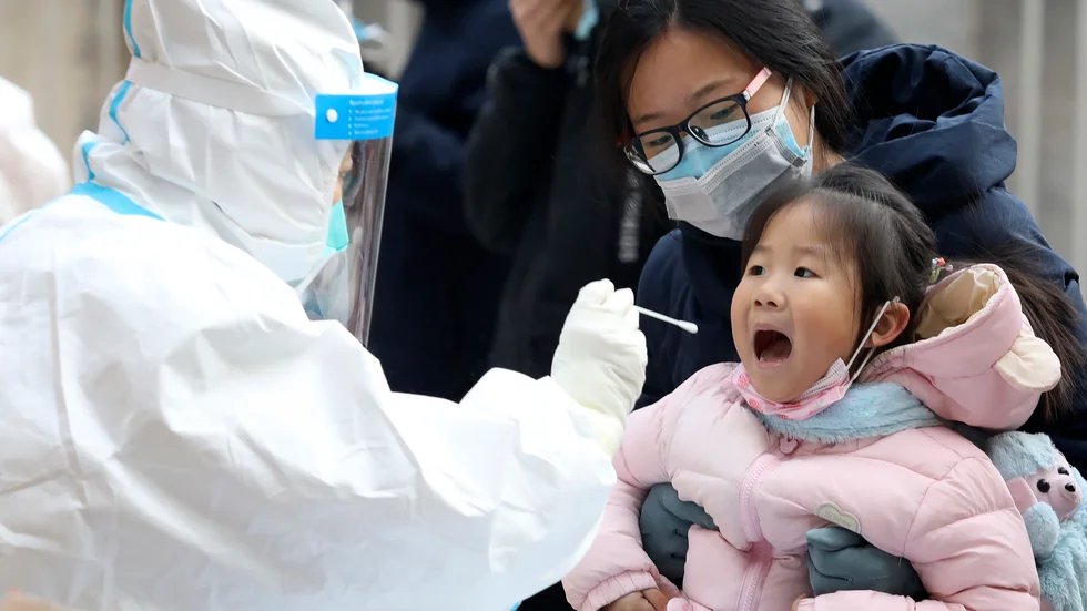 Ett barn testas för covid-19 i Shijiazhuang i Hebeiprovinsen söder om Peking, där restriktioner nu införs för att stoppa smittan. Arkivbild.