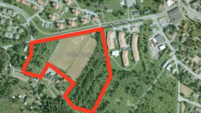 Området innanför röda linjen omfattas av den nya planen. Längre till höger ser man taken från hälsocentralen och centrum. 