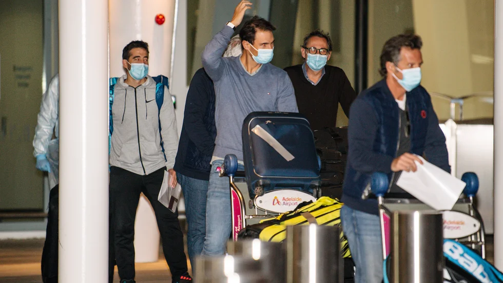 Spaniens Rafael Nadal, i mitten, anlände till flygplatsen i Adelaide i torsdags förra veckan, för att tillbringa två veckor i karantän inför Australian Open. Totalt tio personer med koppling till turneringen har testat positivt för covid-19. Rafael Nadal har inte namngetts som en av dem.