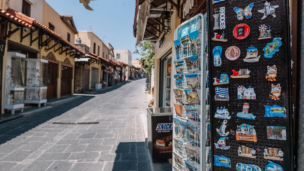 Den vanligtvis myllrande huvudgatan i Rhodos är tom i väntan på turister. Pandemin har lett till ett 98-procentigt tapp i antal turister globalt.