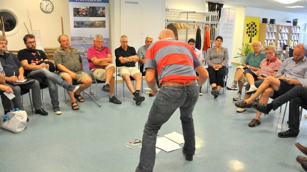 Lars Övling samlar informationslapappar från golvet under Vision Västerviks möte.