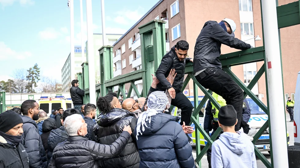 Människor i Rinkeby försökte lugna upprörda män och få dem att klättra ner från ett stängsel.