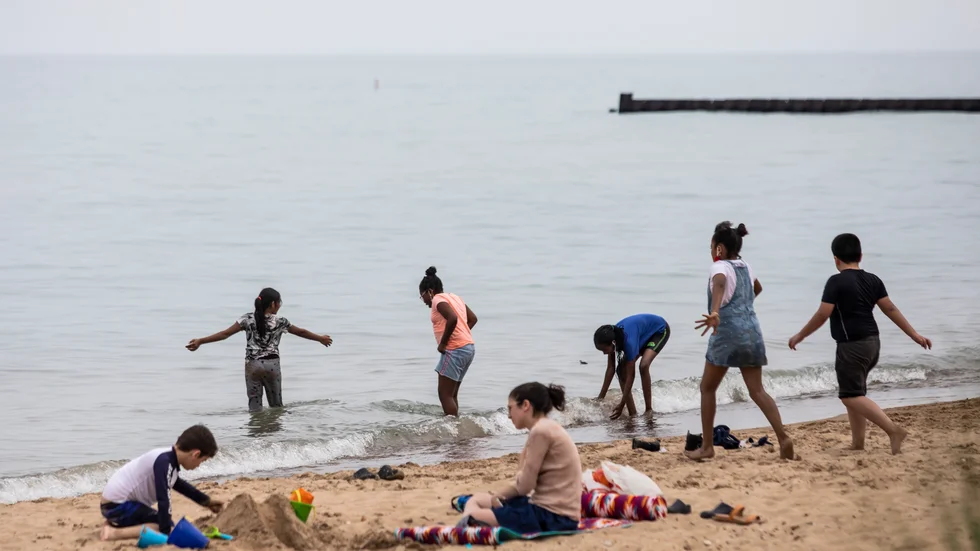 Några barn söker svalka vid Loyola Beach i Chicago på måndagen.
