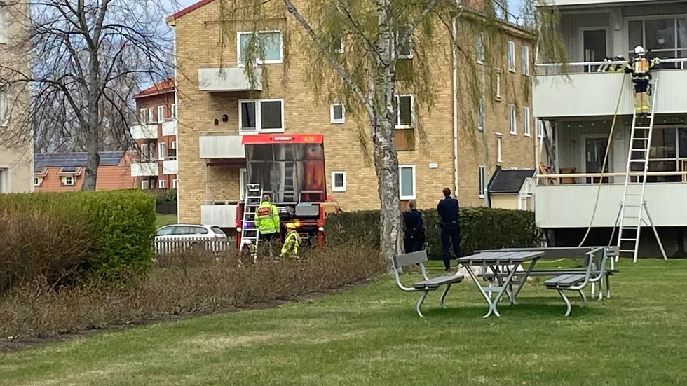 Räddningstjänst och polis på plats utanför balkongen som brann.