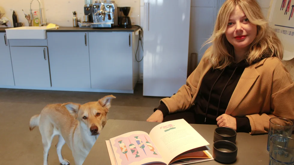Anna Nilsson, illustratör, med den nya boken om vaccin. Hunden Coco är ett fint sällskap på jobbet.