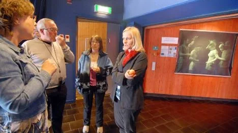 Martin Lestander, Sandra Nielsen  och Katarina Munther får en pratstund med föreläsaren Kickis Åhré Älgamo (till vänster Till höger syns  en bild som ingår i utställningen om det hedersrelaterade våldet.