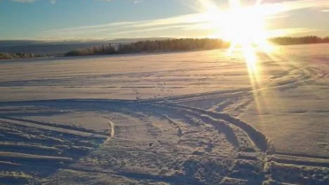 Solen i horisonten från hamnen i Rosvik en januarimorgon.
