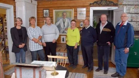 Silvermuseets nya styrelse kommer att jobba i doktor Wallquists (mannen på tavlan) anda. Från vänster: Museichef Ingela Bergman, styrelseledamöterna Britta Flinkfeldt Jansson, styrelseordförande Kurt Burman, Maj-Lis Granström, Dan Brännström och Gunnar Blomgren. Erik Johansson, längst till höger är ersättare i styrelsen.