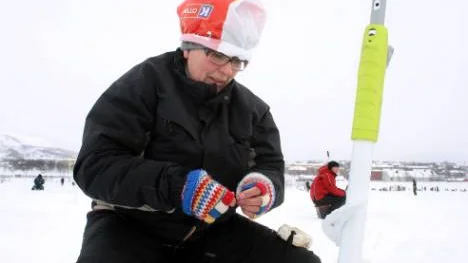 Tarja Anttila från Övertorneå använde sig av en plastpåse kring huvudet för att stå emot blåsten på Luossajärvi.FOTO: Alexander Linder