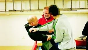 Vid en rekonstruktion i polishusets källare visar en av 20-åringarna (tillsammans med polis) hur han tog tag i 26-åriga Adam Rapacz när de lyfte honom över räcket på Gamle Bro natten den 23 september. Foto: Polisen