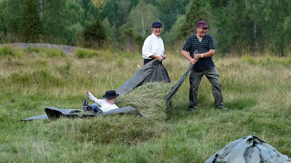 FÖR ALLA ÅLDRAR. De äldsta som är med på den årliga slåttern ute vid Sörsjön är i 80-årsåldern. Yngst vid lördagens ängsslåtter var fyraårige Max Tollerå. Eva Gustavsson (t.v.) är med och drar.