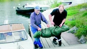 Foto: INGEMAR PETESSON Fskaren Rune Harrysson från Ekö i Loftahammars skärgård och Magnus Rampeltin från Stadsbudskontoret i Västervik lyfter en av de döda sälarna som fraktades till Stockholm.