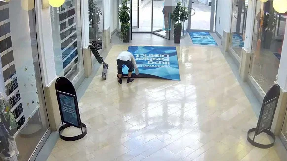 Den 50-årige mannen filmades av en övervakningskamera när han rullade ihop en entrématta i galleria Gränden. (Bilden är hämtad ur förundersökningen.) 