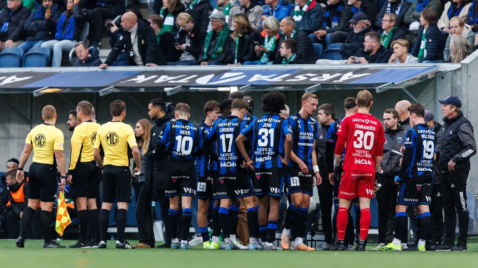 Domarna och Sirius spelare och ledare samlas vid sidlinjen under ett av lördagens avbrott i spelet.